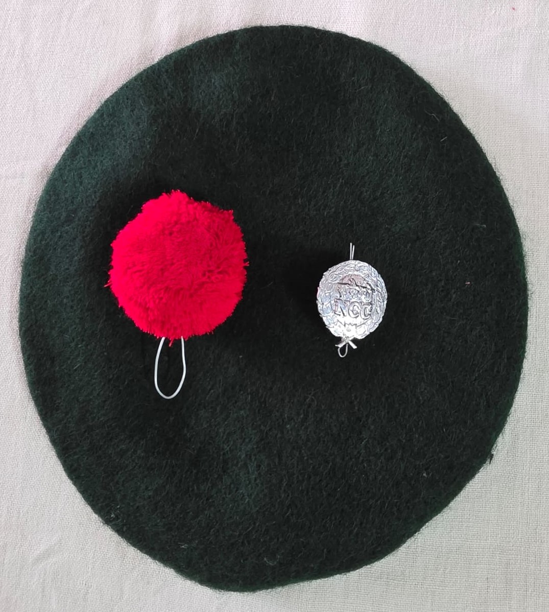Beret with pompom and badge